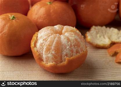 Sweet Spanish fresh peeled mandarin close up with whole ones in the background
