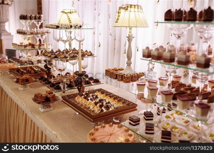Sweet table for wedding. Candy bar with a lot of different candies and sweet chokolate cakes.. Sweet table for wedding. Candy bar with a lot of different candies and sweet chokolate cakes