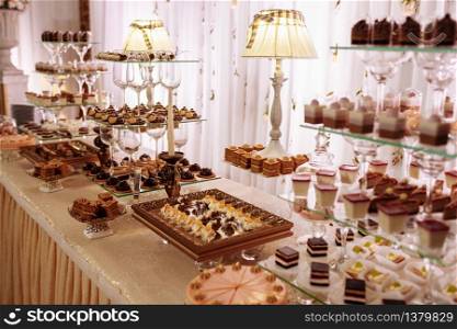 Sweet table for wedding. Candy bar with a lot of different candies and sweet chokolate cakes.. Sweet table for wedding. Candy bar with a lot of different candies and sweet chokolate cakes