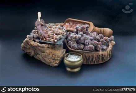 Sweet tamarind seasoned with Sweet and sour taste lay on the wood log slices sprinkler with Himalayan salt, Enjoy snacking when feel exhausted on dark background. Space for text.