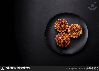 Sweet tasty tart with nuts and honey on a dark concrete background. Delicious nutritious desserts