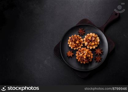 Sweet tasty tart with nuts and honey on a dark concrete background. Delicious nutritious desserts