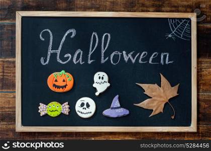 "Sweet terror is coming. Blackboard with the word "Halloween" and cookies"