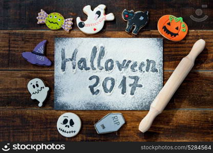 "Sweet terror is coming. The words "Halloween 2017" on a slate with flour and cookies"