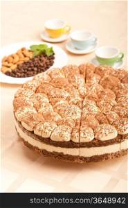 sweet tiramisu cake with almonds, coffee beans and cups