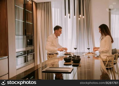 Sweet young couple having a romantic dinner at luxury kitchen