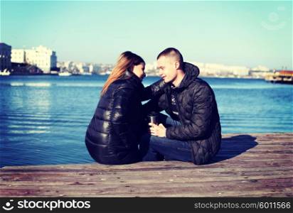 Sweet young couple sitting by the bay