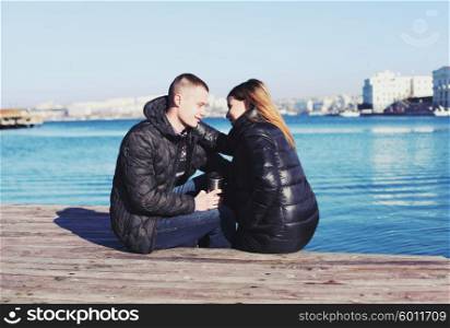 Sweet young couple sitting by the bay