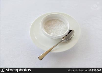 sweetener, carbohydrates, diet and unhealthy eating - sugar bowl and saucer with spoon on table