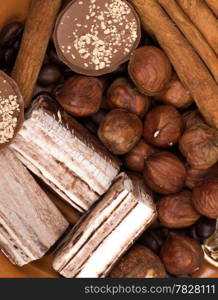 Sweets, cinnamon, nuts and coffee beans on a saucer, on burlap background.