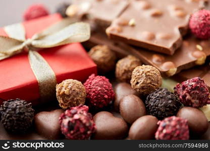 sweets concept - close up of handmade chocolate candies and red gift box. close up of handmade chocolate candies