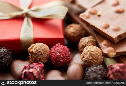 sweets concept - close up of handmade chocolate candies and red gift box. close up of handmade chocolate candies