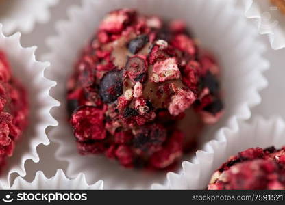 sweets, confectionery and food concept - close up of different handmade candies in paper cups. close up of different candies in paper cups