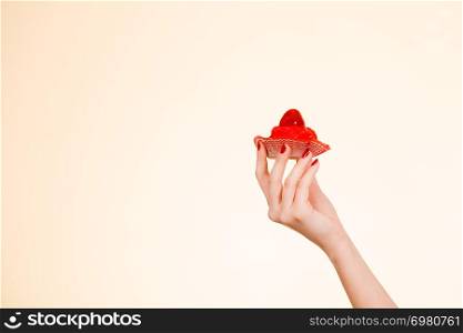 Sweets, junk food, sugar temptation on diet concept. Woman holding sweet delicious cupcake. Woman holding sweet delicious cupcake