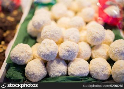 sweets, sale and food concept - coconut cookies on stall. coconut cookies on stall