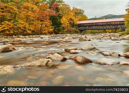 Swift River and old covered Albany Bridge at autumn in White Mountain National Forest, New Hampshire, USA. Fall in New England. 