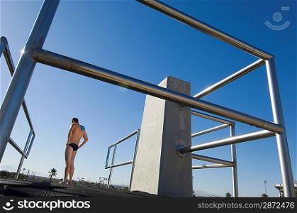 Swimmer standing on diving board