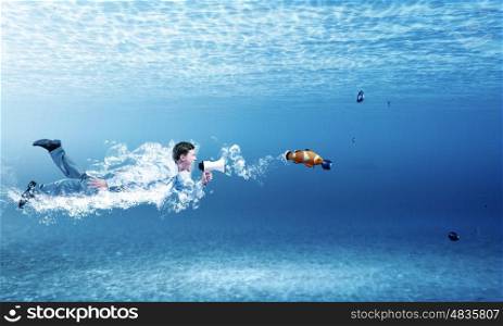 Swimming businessman. Young businessman in suit swimming under water