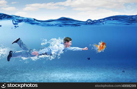 Swimming businessman. Young businessman in suit swimming under water