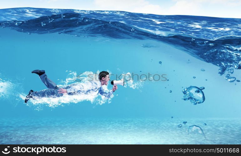 Swimming businessman. Young businessman in suit swimming under water