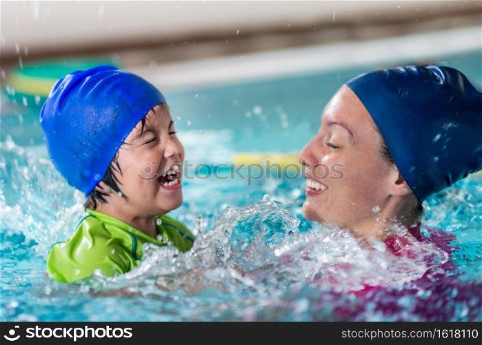 Swimming class fun, little boy with instructor