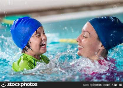 Swimming class fun, little boy with instructor