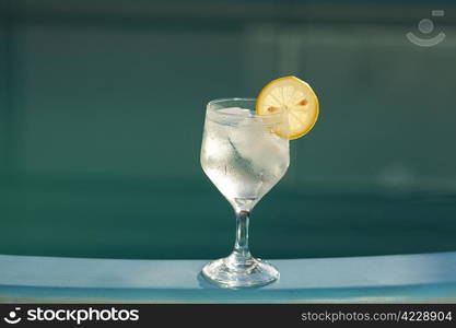 Swimming pool and a wine glass with ice and lemon