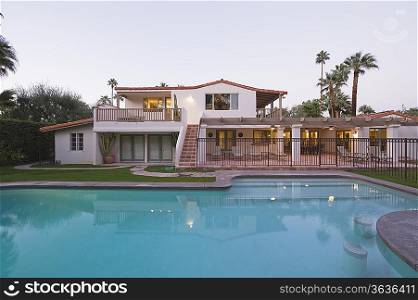 Swimming pool and lit exterior of Palm Springs home exterior