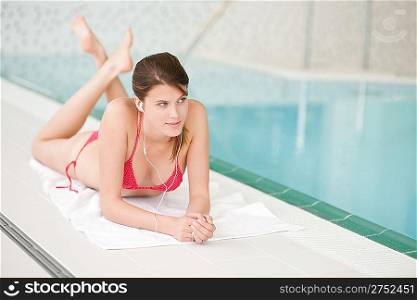 Swimming pool - beautiful woman relax listen to music with ear buds