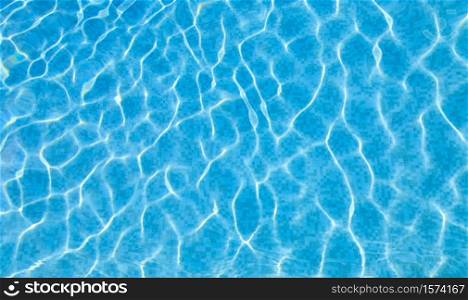 Swimming pool bottom caustics ripple and flow with waves background. Summer background. Texture of water surface. Overhead view