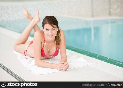 Swimming pool - happy woman relax listen to music with ear buds