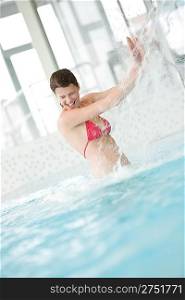 Swimming pool - happy woman under water stream having fun