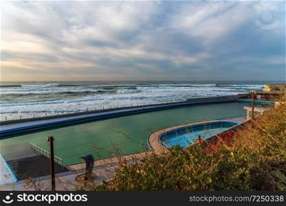 Swimming pool in front of ocean in Big beach  in Sintra Portugal 