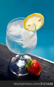 Swimming pool, lounge, a wine glass with ice, lemon and strawberry