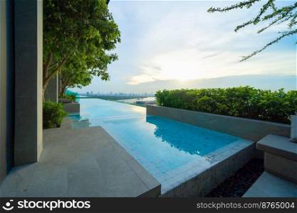 Swimming pool on rooftop of hotel apartment building in Bangkok downtown skyline, urban city view. Relaxing in summer season in travel holiday vacation concept. Recreation lifestyle.