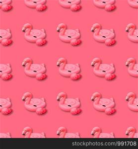 Swimming pool toy in shape of pink flamingo seamless pattern on pink background. Flamingo inflatable cut out. Top view, flat lay.. Swimming pool toy in shape of pink flamingo seamless pattern. Flamingo inflatable cut out