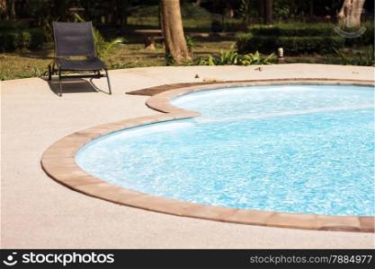 Swimming pool with beach chairs, stock photo