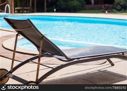 Swimming pool with beach chairs, stock photo