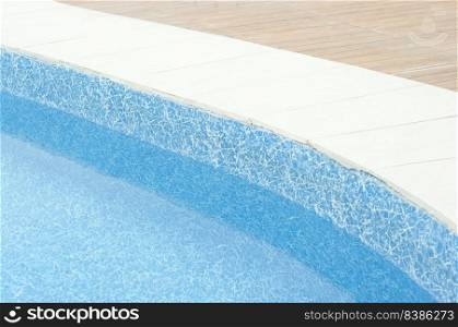 Swimming pool with clean blue water under the bright sunlight.