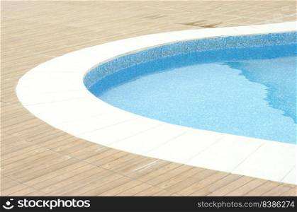 Swimming pool with clean blue water under the bright sunlight.