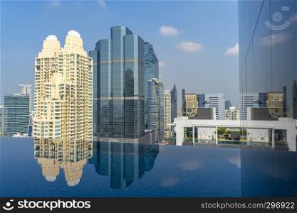 Swimming pool with modern building in business city center and blue sky in sunny day.