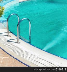 Swimming pool with stair and blue relaxing water in a hotel