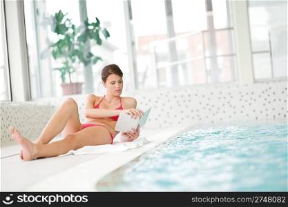 Swimming pool - woman relax with book lying down