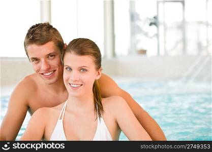 Swimming pool - young cheerful couple have fun by poolside