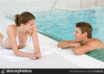 Swimming pool - young happy couple relax on poolside