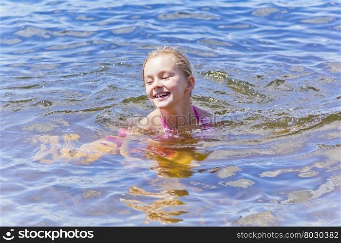 Swimming smiling cute girl seven years old