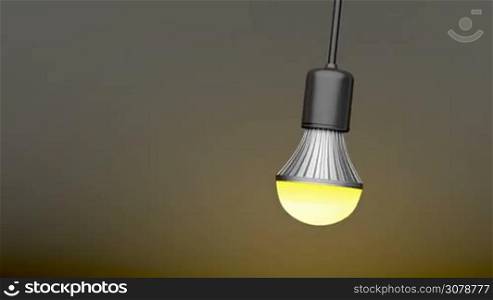Swinging LED light bulb in the dark room
