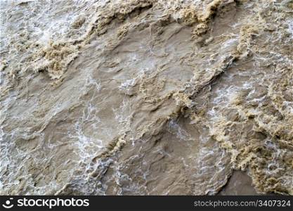 Swirling muddy water in a fast river