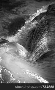 Swirling water from waterfall as natural design wallpaper in stunning black and white