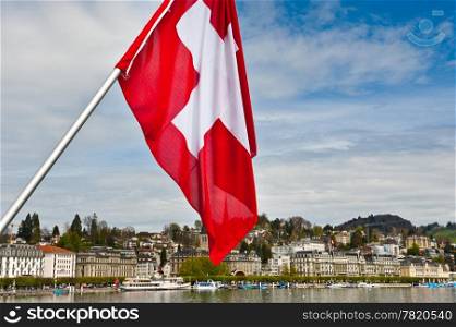 Swiss Flag on the Background of the Embankment of the River Reuss in Lucerne